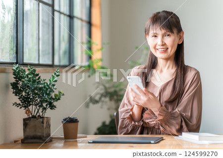 Middle-aged Asian women doing telework/nomad work in a cafe 124599270