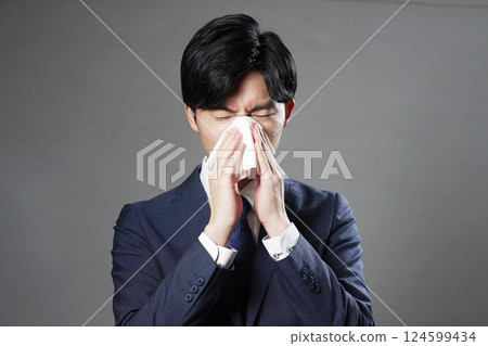 Businessman blowing his nose black background Businessman blowing his nose black background 124599434