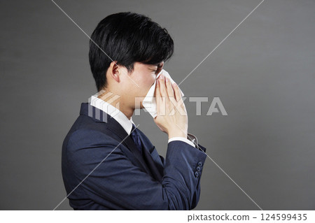 Businessman blowing his nose black background Businessman blowing his nose black background 124599435