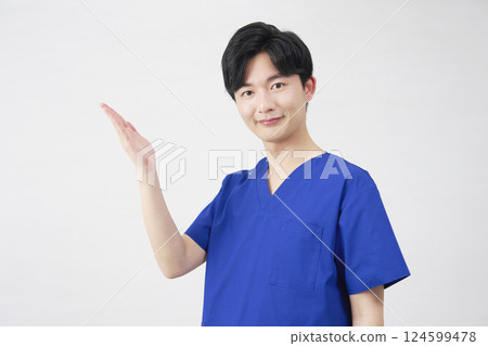 Doctor, nurse, dentist, caregiver, man pointing to the left with palm, white background 124599478