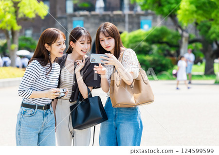 Girls' trip: Young women taking selfies at Osaka Castle Park 124599599