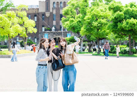 Girls' trip: Young women taking selfies at Osaka Castle Park 124599600