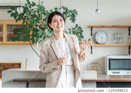 Young Asian woman in a suit eating a protein bar or nutrition bar for breakfast or snack Young Asian woman in a suit eating a protein bar or nutrition bar for breakfast or snack 124599613