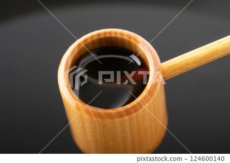 Close-up of black vinegar scooped up with a ladle Close-up of black vinegar scooped up with a ladle 124600140