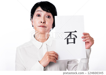 一名中年婦女手拿一張寫有「不」字的紙條，用拒絕的表情看著鏡頭 124600345