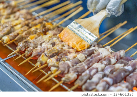 燒烤師傅為肉串刷調味料 燒烤師傅為肉串刷調味料 124601355