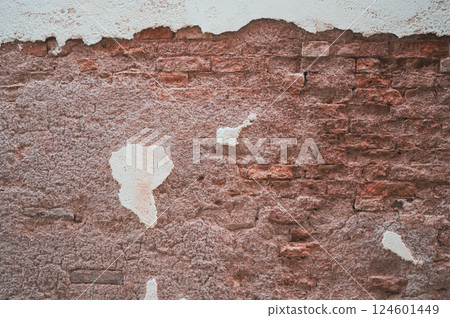 Brick wall with pieces of plaster. Wall of an old building in need of renovation. Aged wall texture of brick building close up. Grunge background with red and white blocks and layers of cement stucco Brick wall with pieces of plaster. Wall of an old building in need of renovation. Aged wall texture of brick building close up. Grunge background with red and white blocks and layers of cement stucco 124601449