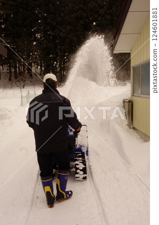 大雪地區的一個男人正在清理家裡的積雪 124601881