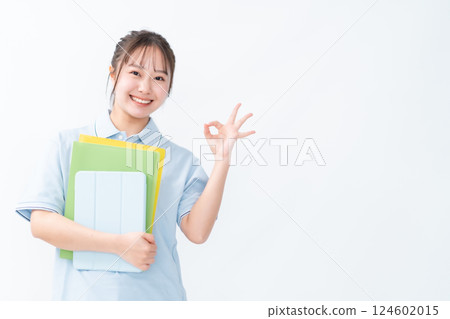 A female student in a polo shirt making an OK pose 124602015
