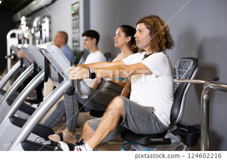 Motivated man doing cardio workout on exercise bike in gym Motivated man doing cardio workout on exercise bike in gym 124602216