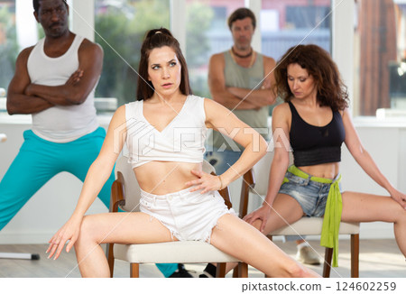 Adult couples of different nationalities learn to lap dance dance using chairs 124602259