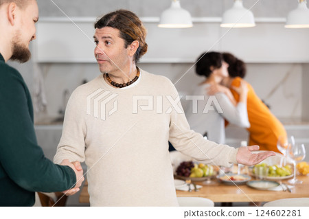 In home, male friends shake hands, say goodbye after socializing and gatherings. 124602281