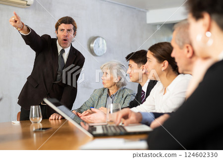 Angry male boss reprehending colleagues on meeting in office Angry male boss reprehending colleagues on meeting in office 124602330