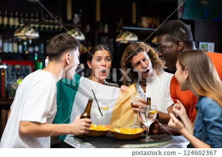 Group of excited sports fans celebrating victory of favorite Irish team in bar Group of excited sports fans celebrating victory of favorite Irish team in bar 124602367