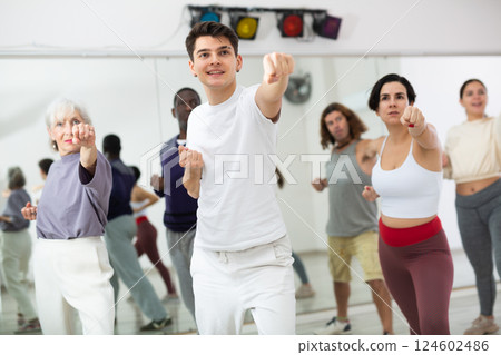 Caucasian man rehearsing modern dance with group in dance school Caucasian man rehearsing modern dance with group in dance school 124602486