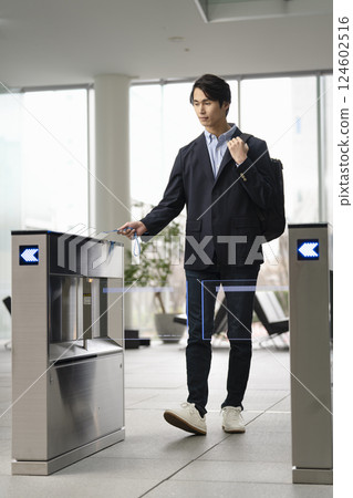 Young businessman passing through a security gate in an office building 124602516