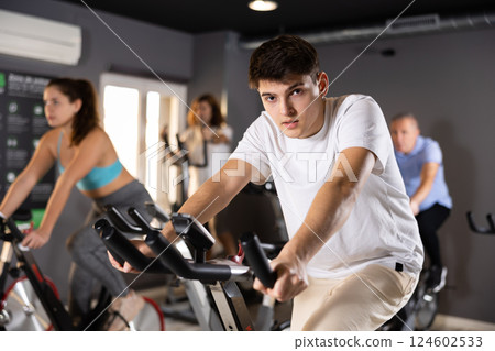 Guy doing cardio training on stationary bike in gym 124602533