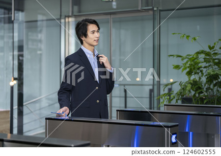 Young businessman passing through a security gate in an office building 124602555