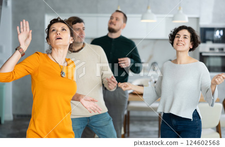 Friends dancing. Cheerful young people dancing and drinking while enjoying home party on room Friends dancing. Cheerful young people dancing and drinking while enjoying home party on room 124602568