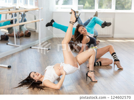 Fit woman showcasing sensual vogue dance on floor at group class 124602570