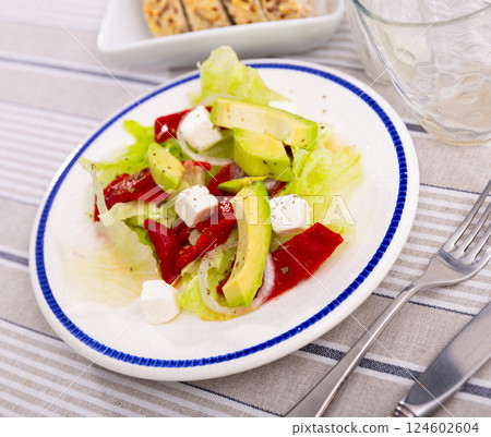 Salad with avocado, peppers, cheese and onions on a white plate Salad with avocado, peppers, cheese and onions on a white plate 124602604