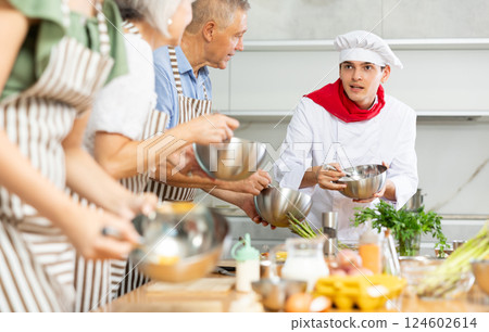 Young guy cook teaches to cook group of people 124602614