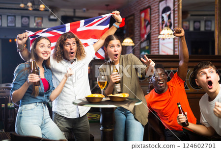 Group of football fans cheering for favorite British team in sports bar Group of football fans cheering for favorite British team in sports bar 124602701