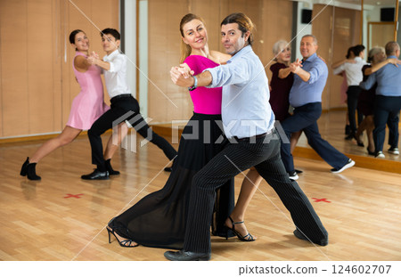 Cheerful man and woman practicing ballroom dances in ballroom 124602707
