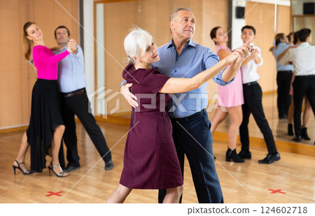 Aged woman learning to dance Vienneze waltz with partner in dancing class Aged woman learning to dance Vienneze waltz with partner in dancing class 124602718