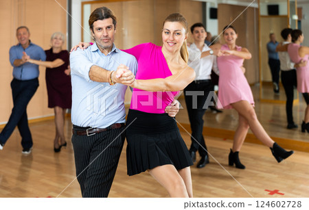Happy couple performing a paired dance in ballroom 124602728