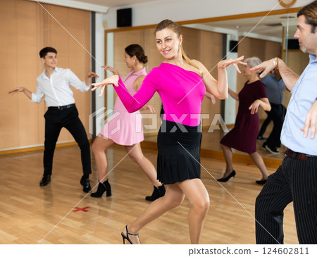 Young female amateur dancer practicing twist with partner 124602811