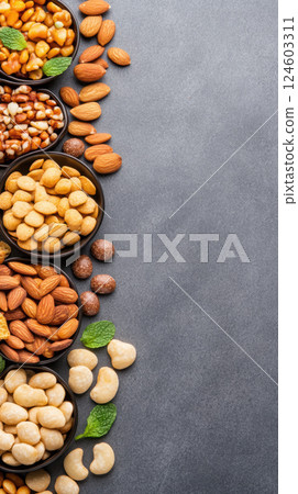Assorted nuts and seeds on gray surface with space for text 124603311