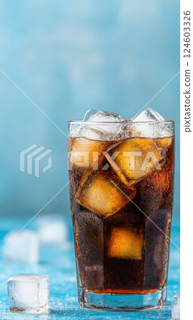 refreshing glass of with ice cubes against blue background refreshing glass of with ice cubes against blue background 124603326