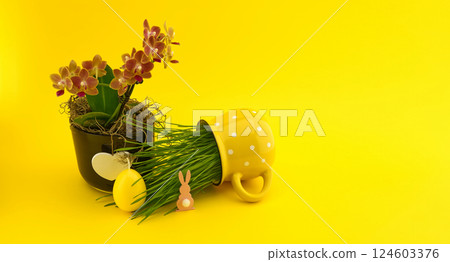 Festive easter decoration featuring an orchid, egg, and bunny on a bright yellow background. Festive easter decoration featuring an orchid, egg, and bunny on a bright yellow background. 124603376