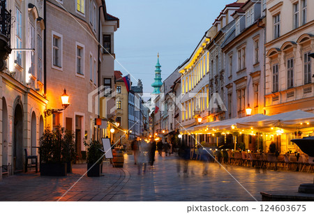 Rare passers-by walk along houses on Venturska Street in Bratislava, evening time 124603675