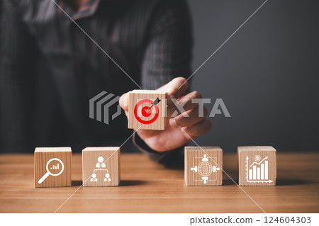 hand of businessman holding target icon of success, leaders project and business success, achieving goals objective target strategy planning and concept. 124604303