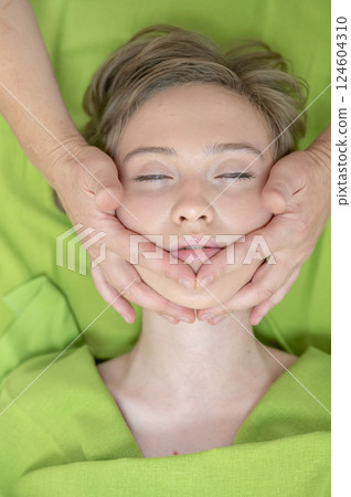 Top view of woman getting facial massage.  124604310