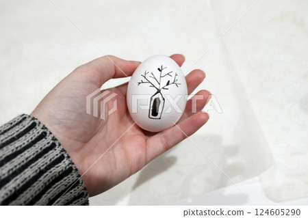 A hand holding a traditional Ukrainian pysanka egg decorated Easter tree, symbolizing heritage and tradition. Happy Easter 2025 in Ukraine 124605290