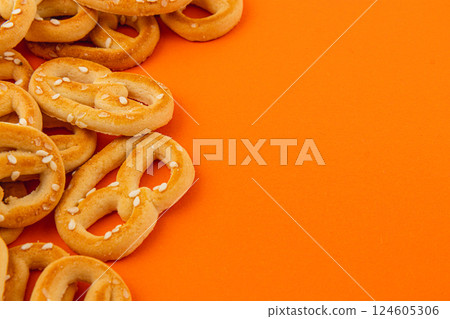 Delicious pretzels scattered on a bright orange background perfect for snacking Delicious pretzels scattered on a bright orange background perfect for snacking 124605306