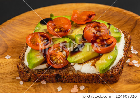 Delicious open-faced sandwich with fresh ingredients on wooden plate Delicious open-faced sandwich with fresh ingredients on wooden plate 124605320