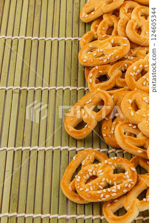 Freshly baked pretzels scattered on a bamboo mat during a casual gathering 124605344