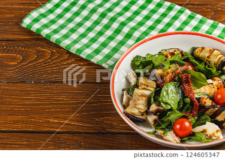 Grilled vegetable salad with spinach and cherry tomatoes in rustic setting 124605347