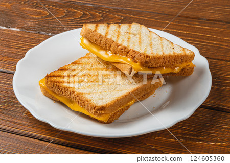 Grilled cheese sandwich served on a white plate for brunch or lunch needs 124605360