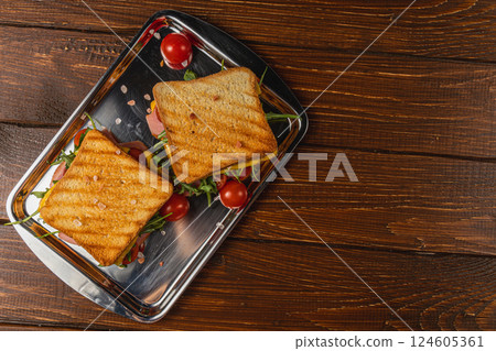 Delicious grilled cheese and ham sandwich served with fresh tomatoes 124605361