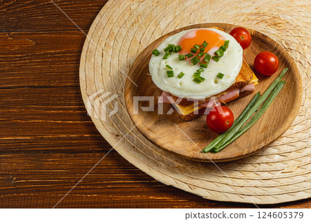 Delicious breakfast with fried egg, ham, and fresh tomatoes on wooden platter 124605379