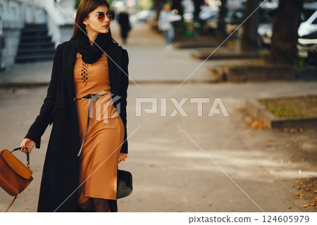 stylish girl walking through the city on a warm sunny autumn day stylish girl walking through the city on a warm sunny autumn day 124605979