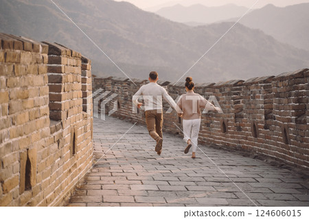 young couple running and twirling at the Great Wall of China. Newly married couple on their honeymoon to the Great Wall of China near Beijing China. 124606015