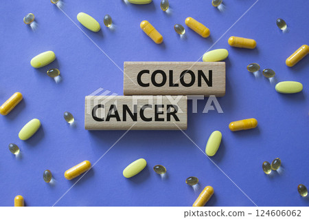 Colon Cancer symbol. Concept word Colon Cancer on wooden blocks. Beautiful purple background with pills. Medicine and Colon Cancer concept. Copy space 124606062