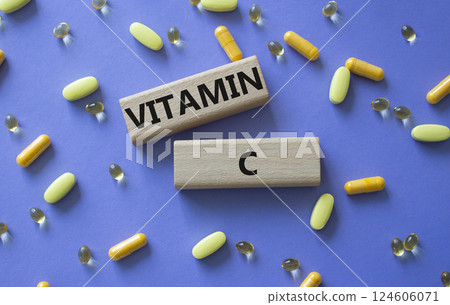 Vitamin C symbol. Concept word Vitamin C on wooden blocks. Beautiful purple background with pills. Medicine and Vitamin C concept. Copy space 124606071