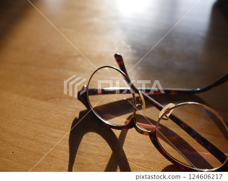 Glasses on a desk, thoughts, a ray of light, a commitment to possibility, inspiration, the light points Glasses on a desk, thoughts, a ray of light, a commitment to possibility, inspiration, the light points 124606217